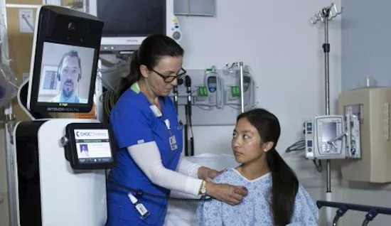 A remote physician using RP-VITA to talk with the patient and facilitate a physical examination