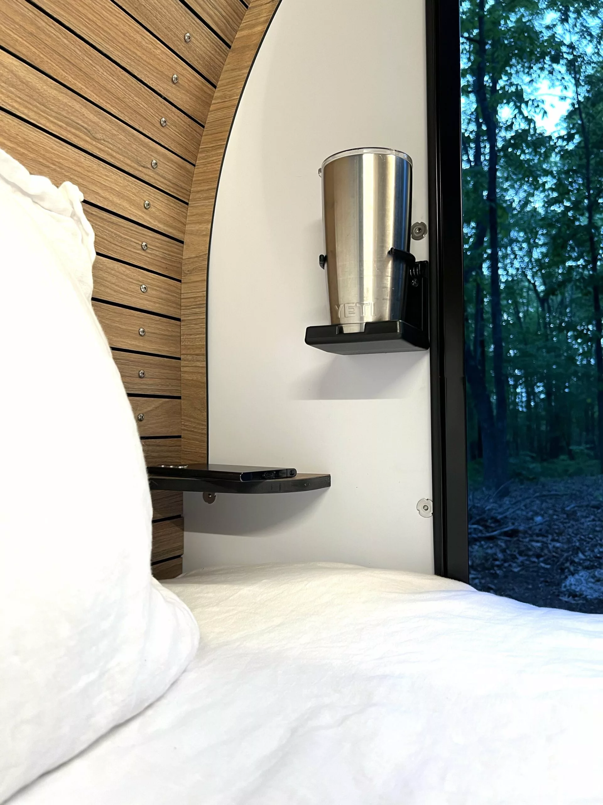 A cupholder and small phone shelf with wireless charging add nightstand-style convenience with a small footprint