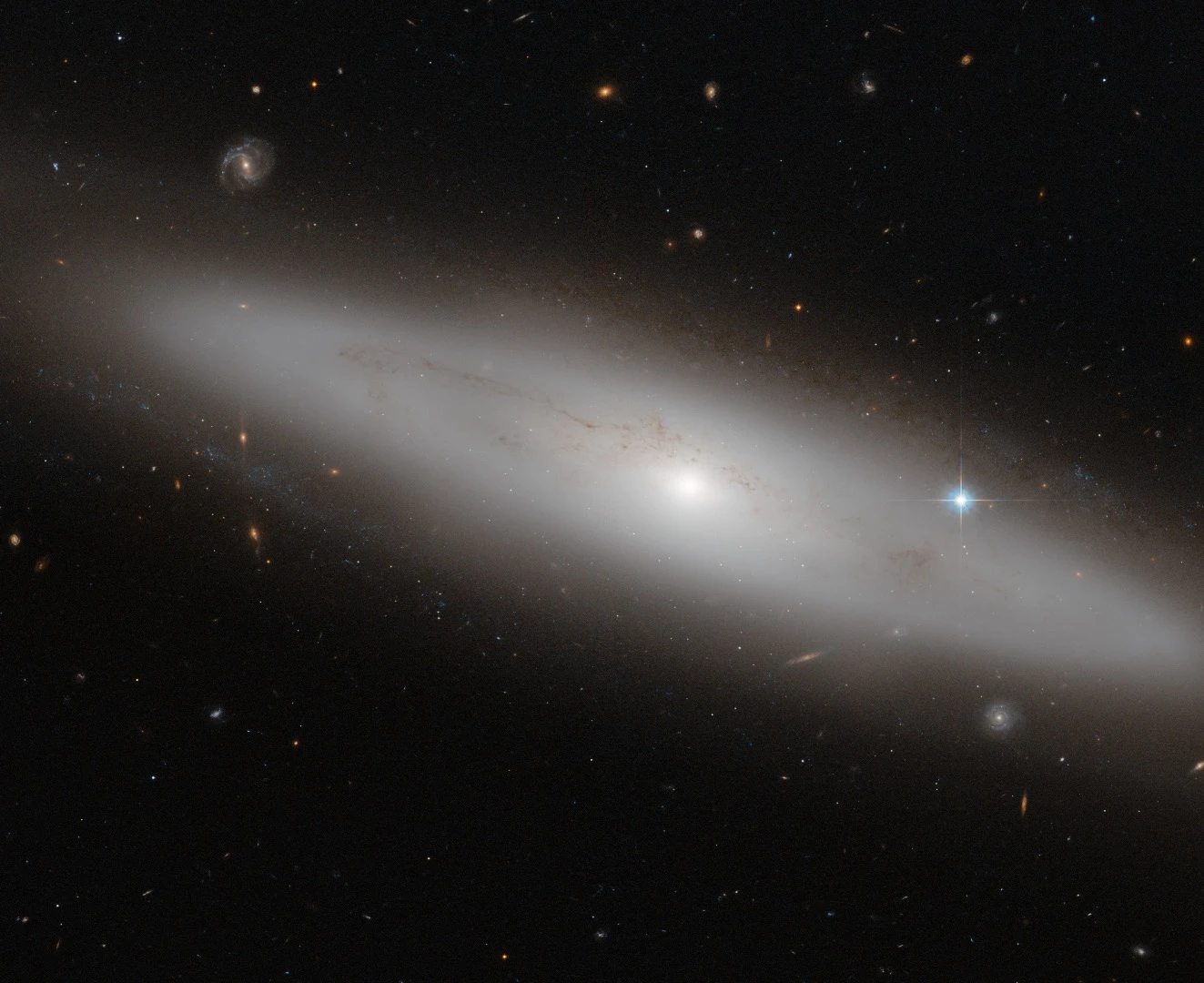 The constellation of Virgo (The Virgin) is the largest of the Zodiac constellations, and the second largest overall after Hydra (The Water Snake). Its most appealing feature, however, is the sheer number of galaxies that lie within it. In this picture, among a crowd of face- and edge-on spiral, elliptical, and irregular galaxies, lies NGC 4866, a lenticular galaxy situated about 80 million light-years from Earth