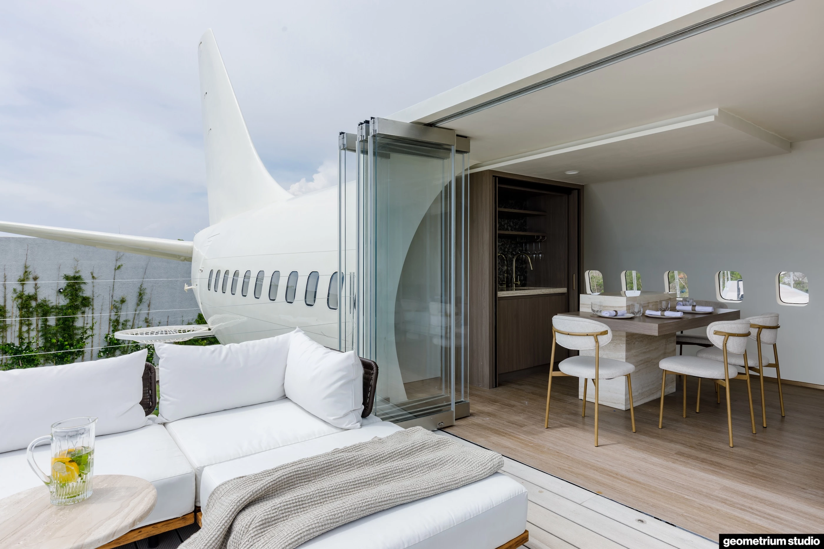 The Private Jet Villa's center features a large glass door, opening up the space to the outside