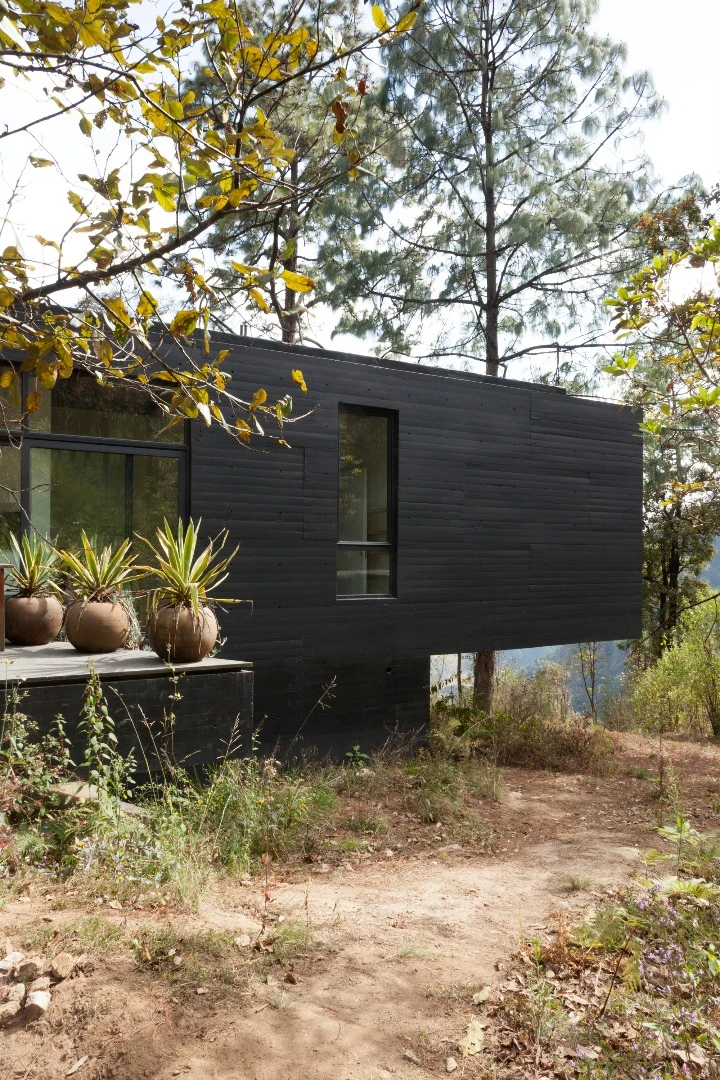 The black paint of the Casa de la Roca is also an effort to blend in with the landscape, with the architects aiming for a “certain anonymity in front of the vegetation and exuberant views.”