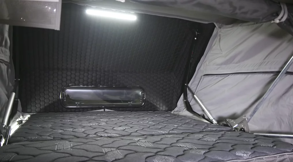 A look inside at the bed, which sizes just under a queen, and the overhead lighting