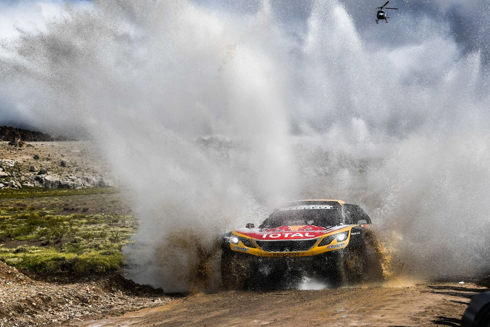 Opportunities for a wash are limited; here Peterhansel and Cottret's Peugeot gets a high-pressure hose down thanks to a river crossing