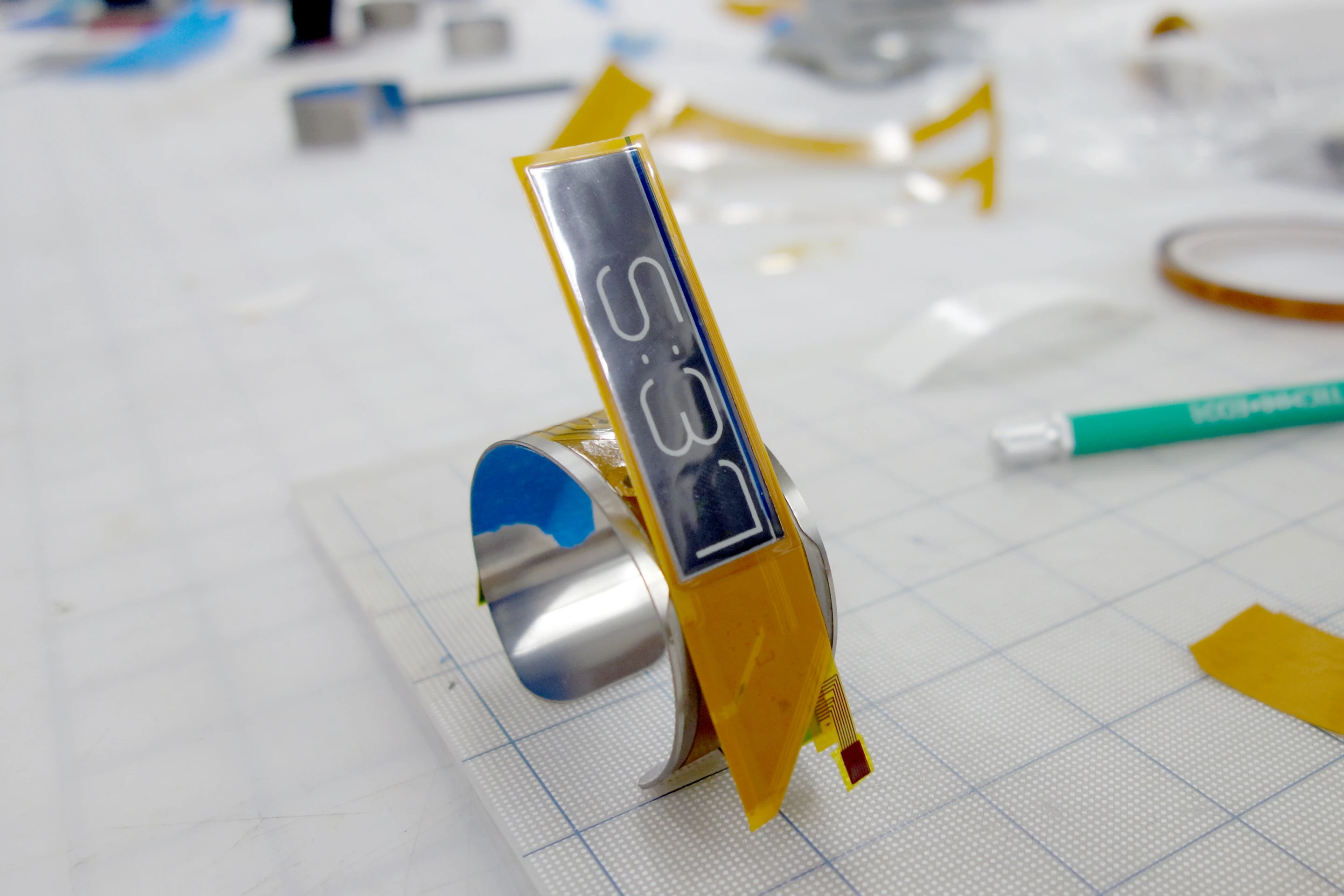 A single piece of flexible stainless steel has a 0.5 mm channel etched into its upper surface, into which the flexible e-ink components, a Seiko Epson SoC and an embedded Thinergy MEC are laminated