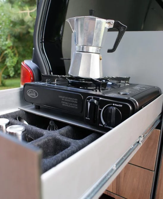 The cooking module stores a stove, pots and pans, and other cooking/serving tools