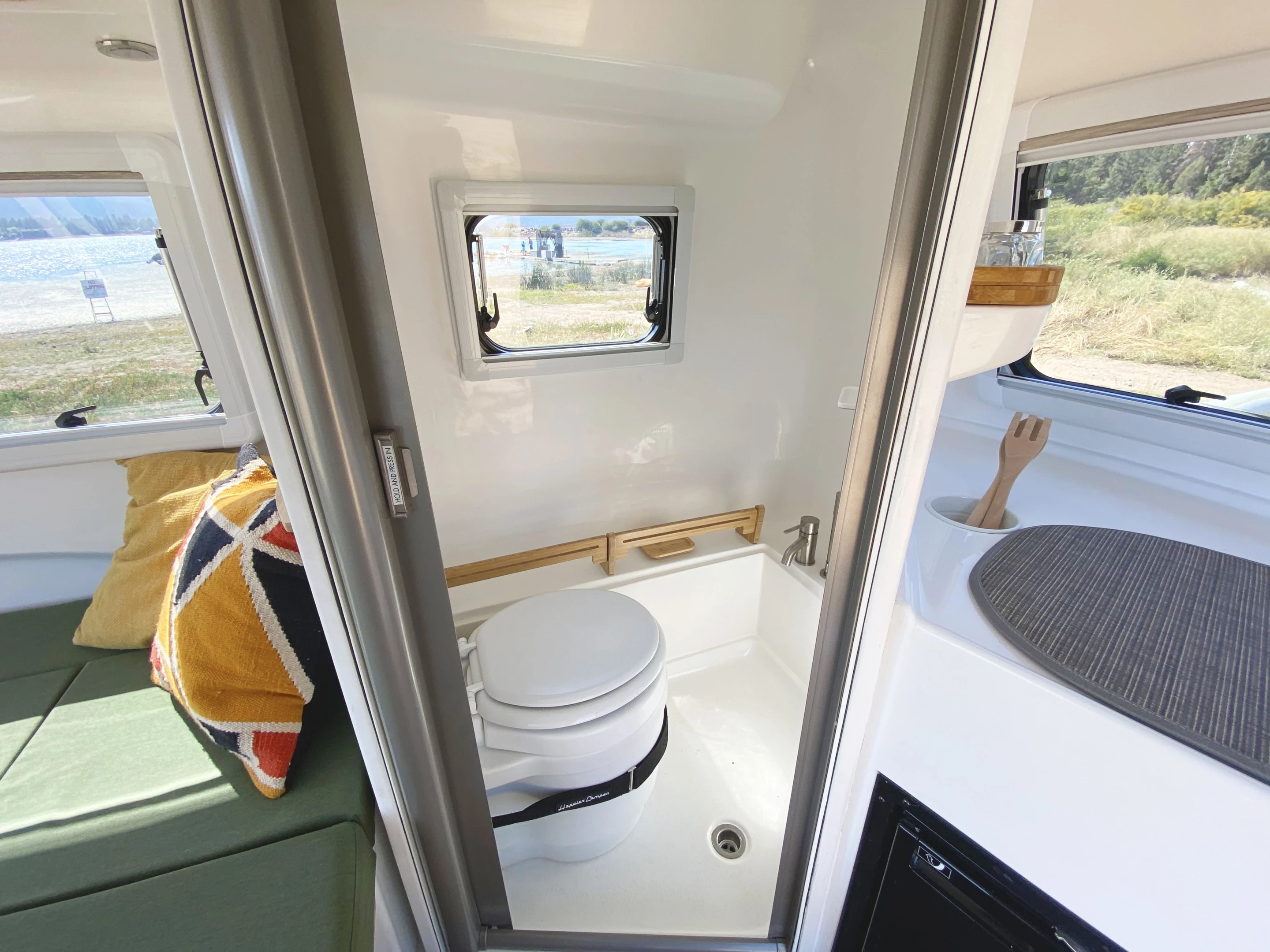 Happier Camper keeps its bathroom simple with a toilet, shower, floor drain and basin-less sink
