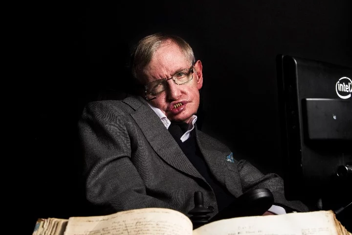 Stephen Hawking pictured with Isaac Newton's own annotated copy of Principia Mathematica