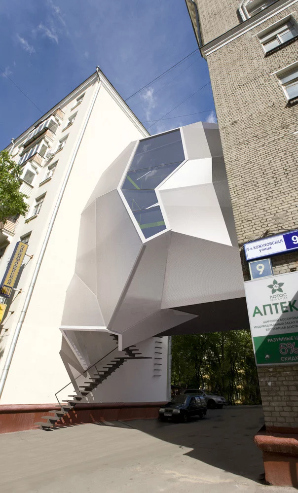 The Parasite office in Moscow from za bor architects utilizes the abandoned space between buildings to create a multistory office environment. The structure sits above the laneway between the buildings and resembles an organic growth seemingly joining up the two disparate buildings on either side
