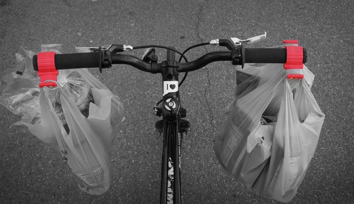The Bag Buddy is a simple handlebar clamp designed to make carrying shopping bags on a bicycle easier