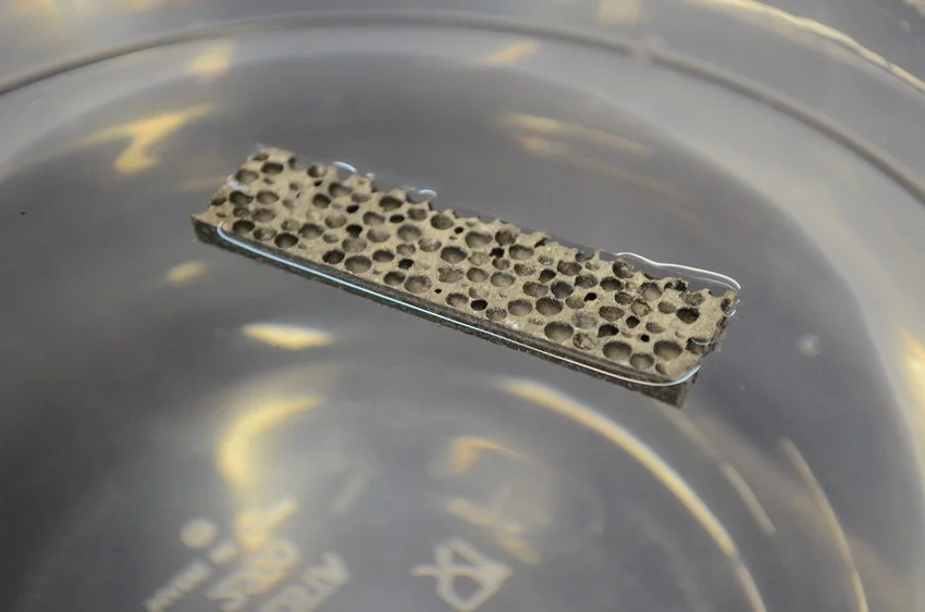 The new lightweight metal matrix foam floating in a beaker of water
