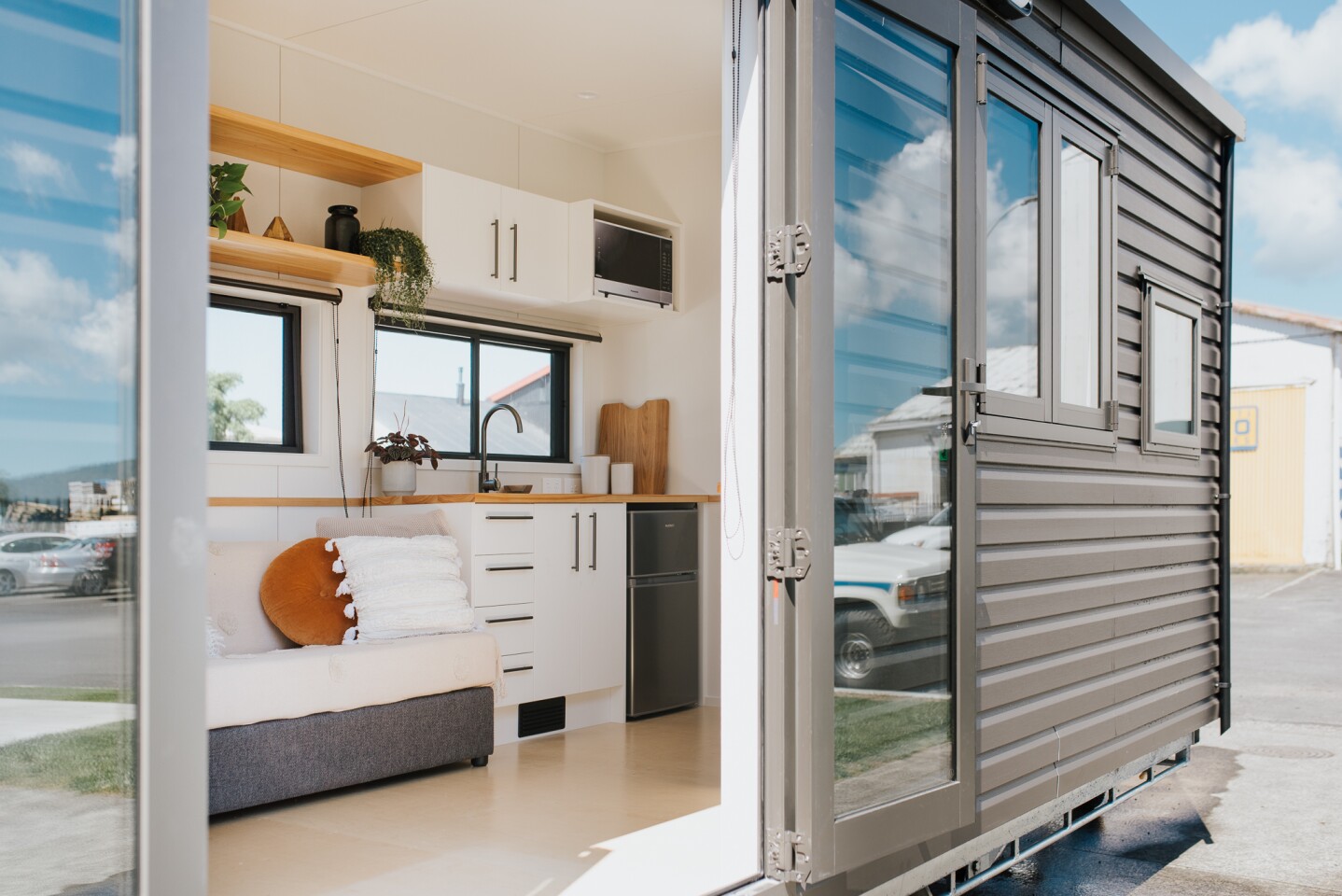 The Tadpole Tiny House is accessed by double glass doors that open up the home to the outside