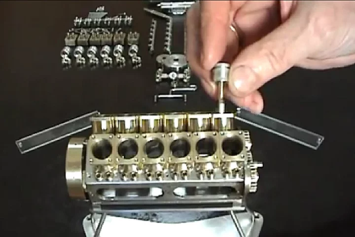Patelo inserts a tiny piston into his miniature V12 engine