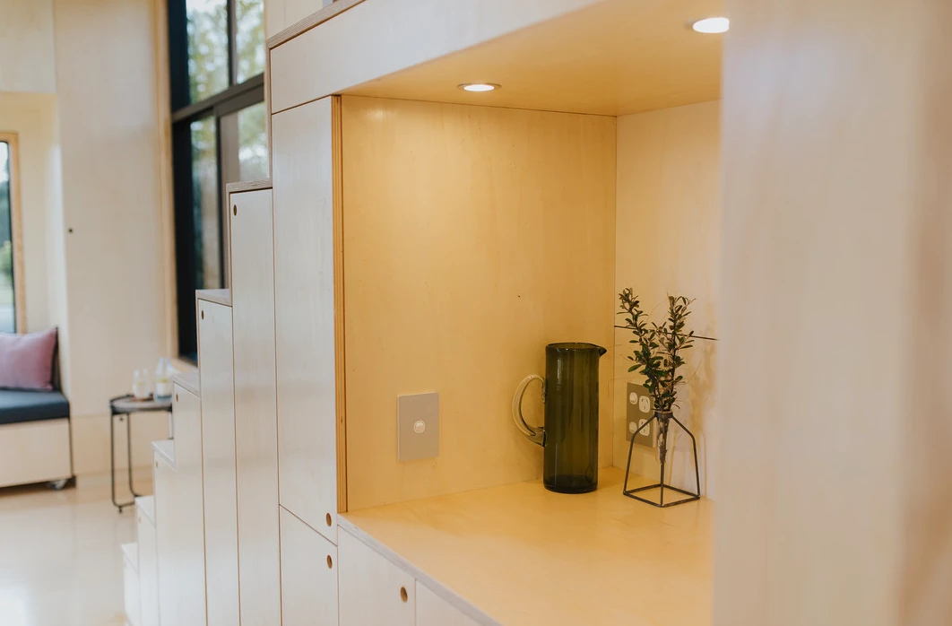 The First Light Tiny House's storage-integrated staircase includes a small nook