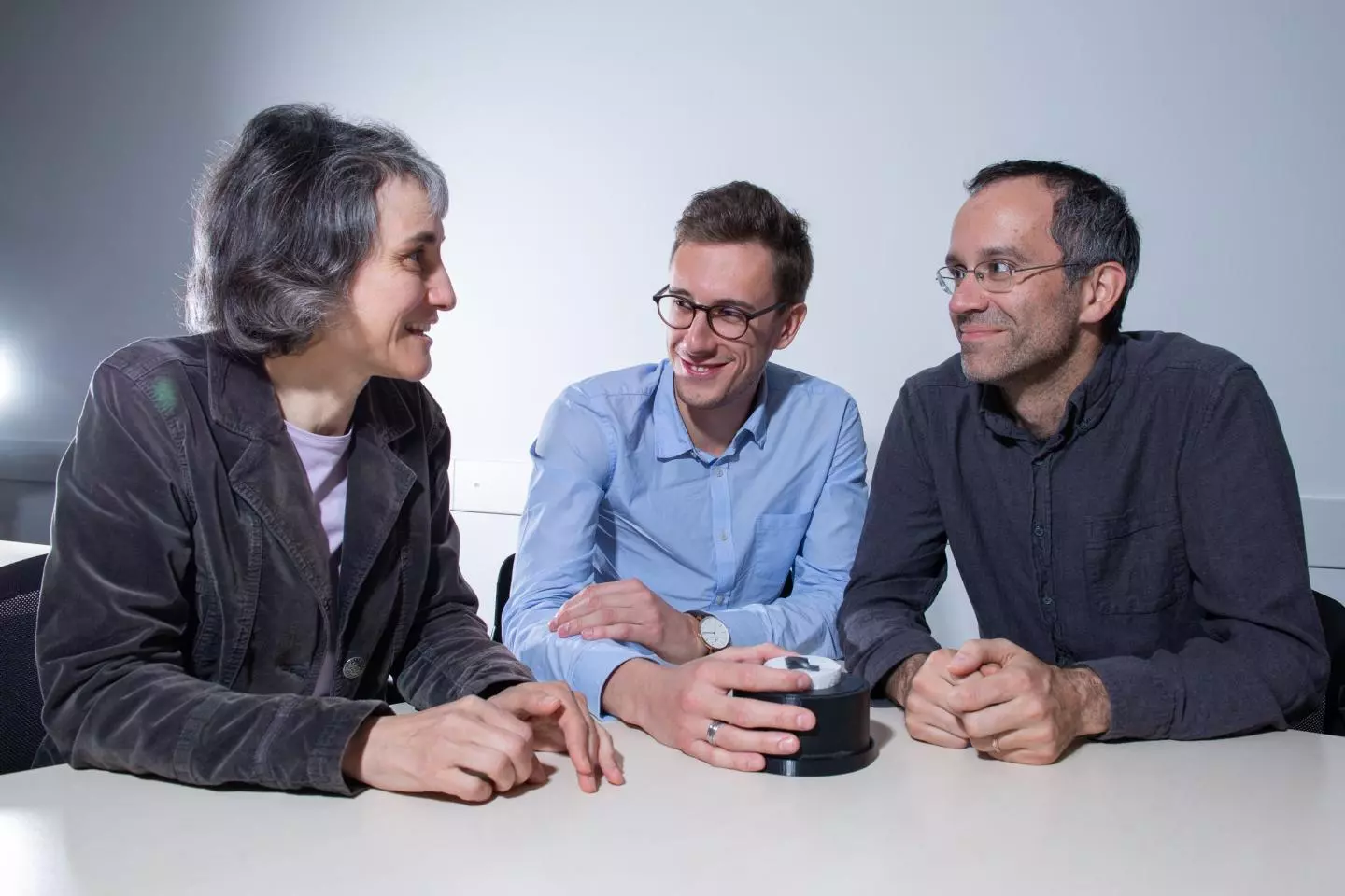 Lead scientists Laura Heyderman (left), Paolo Testa (center) and Eric Dufresne, with a strip of the new material in a magnetic field
