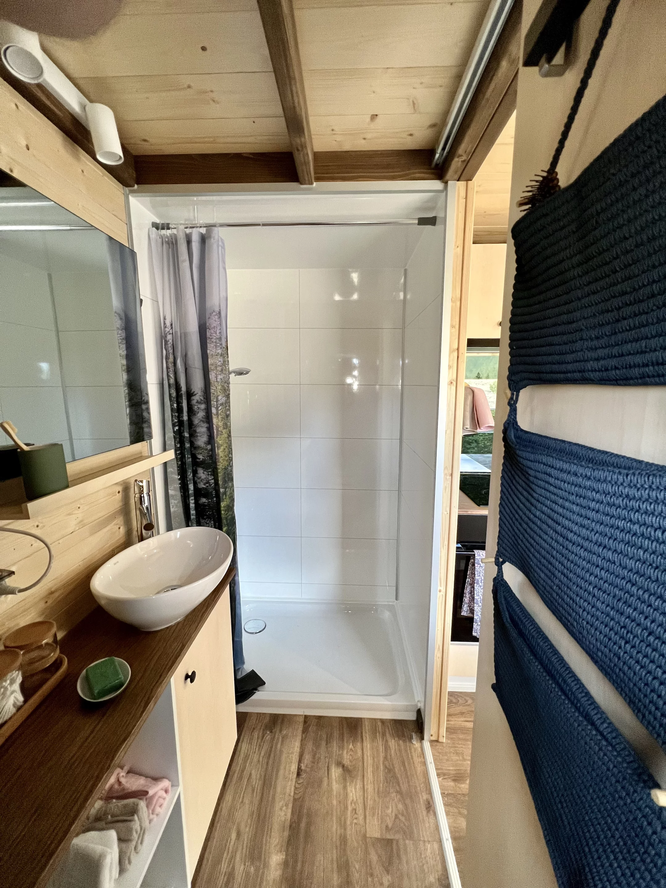 The Sunshine tiny house's bathroom includes a sink, shower, and toilet