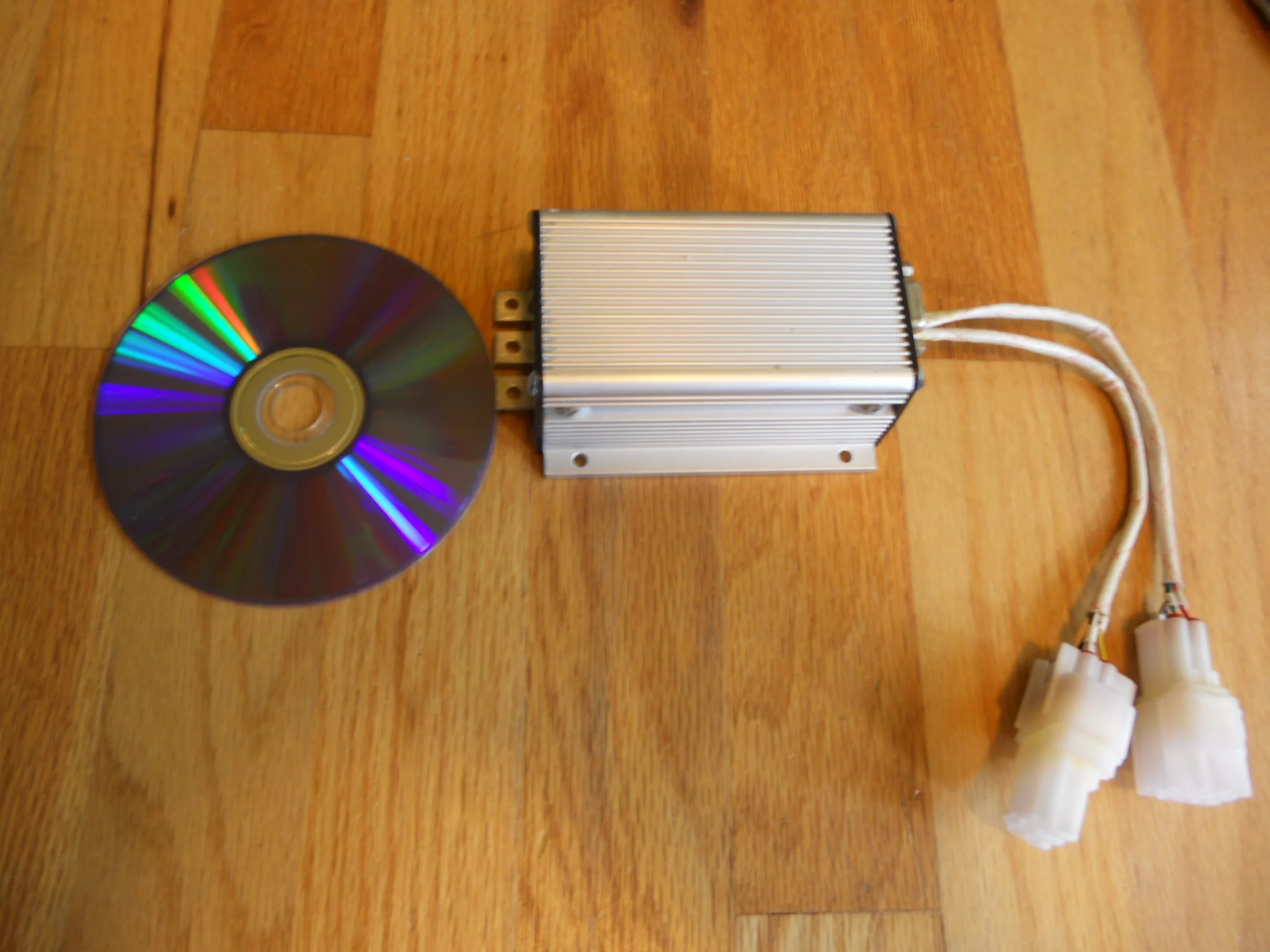 A Kelly KDS72200E controller placed next to a DVD for size comparison