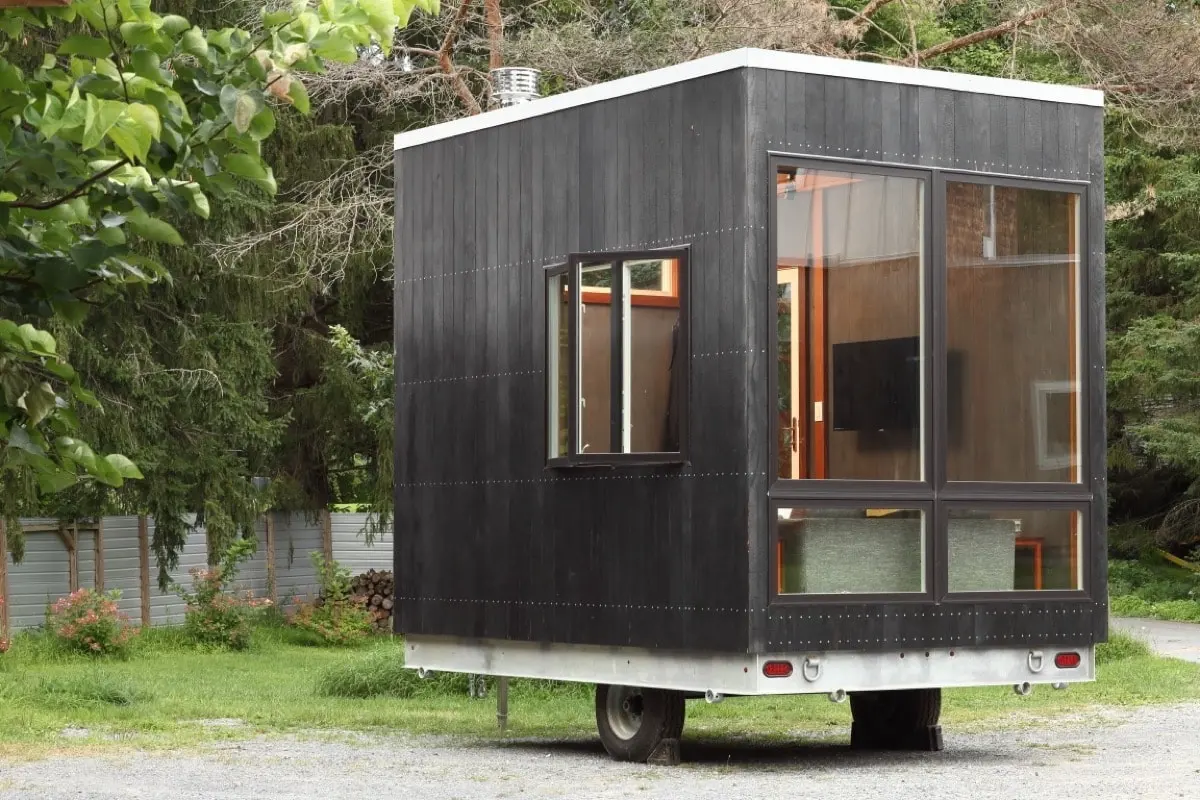 Space-saving cuboid tiny house stows a bed beneath its floor