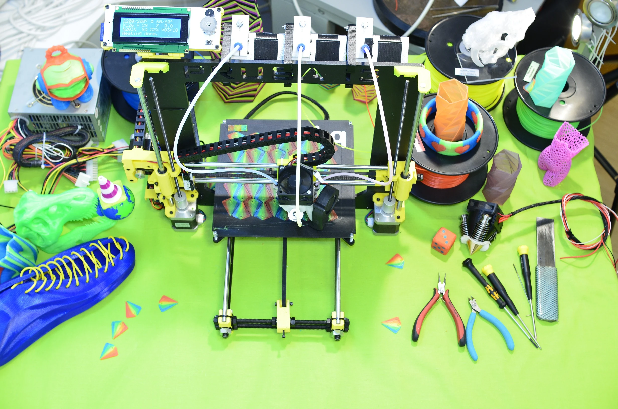 Overhead view of a 3D printer with RepRap.me's Diamond Hotend, showing the three extruder stepper motors that push the plastic filament into the printer