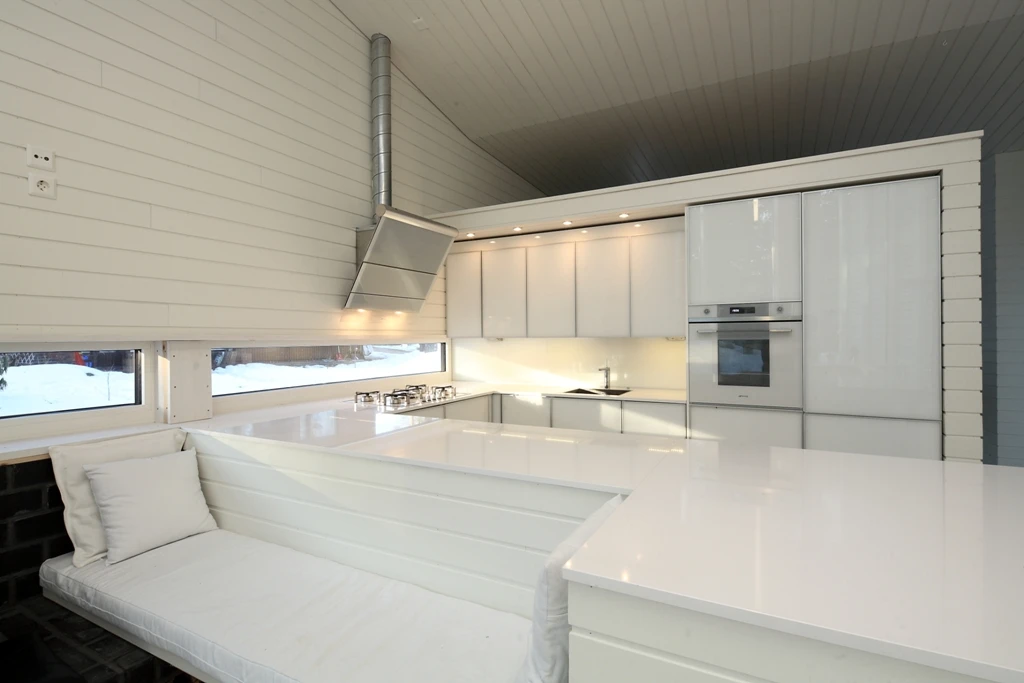 The interior design possesses a continuous composition, where the walls, kitchen and even living room furniture are all seamlessly built into to each other