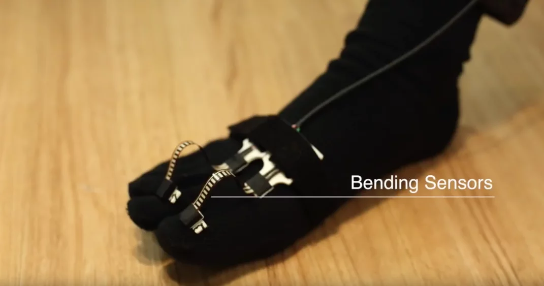 The robot hands are controlled by sensors that track a wearer's toe movements