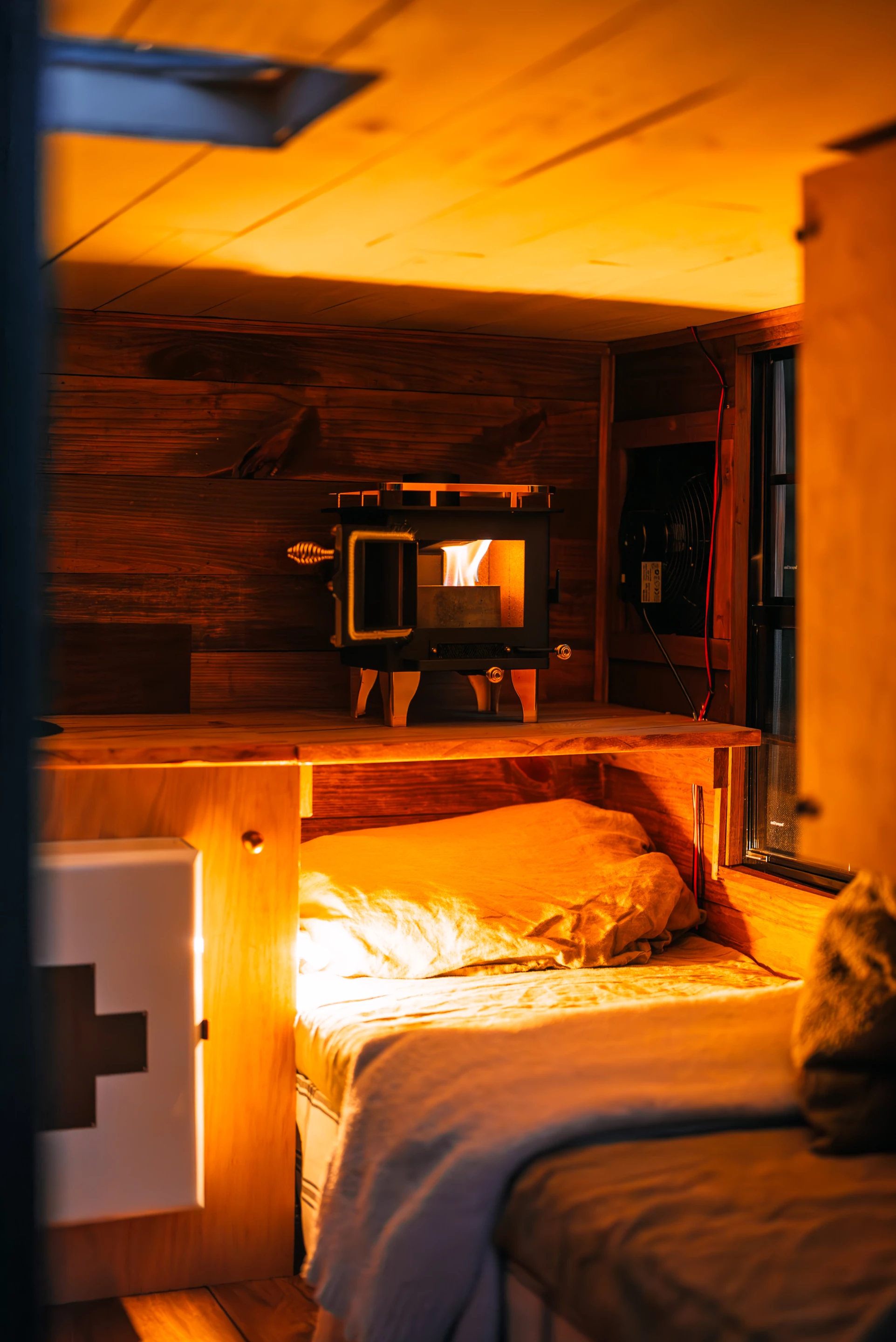 The micro-camper's includes a small alcohol-burning stove and a kitchen area with a functioning sink and tap