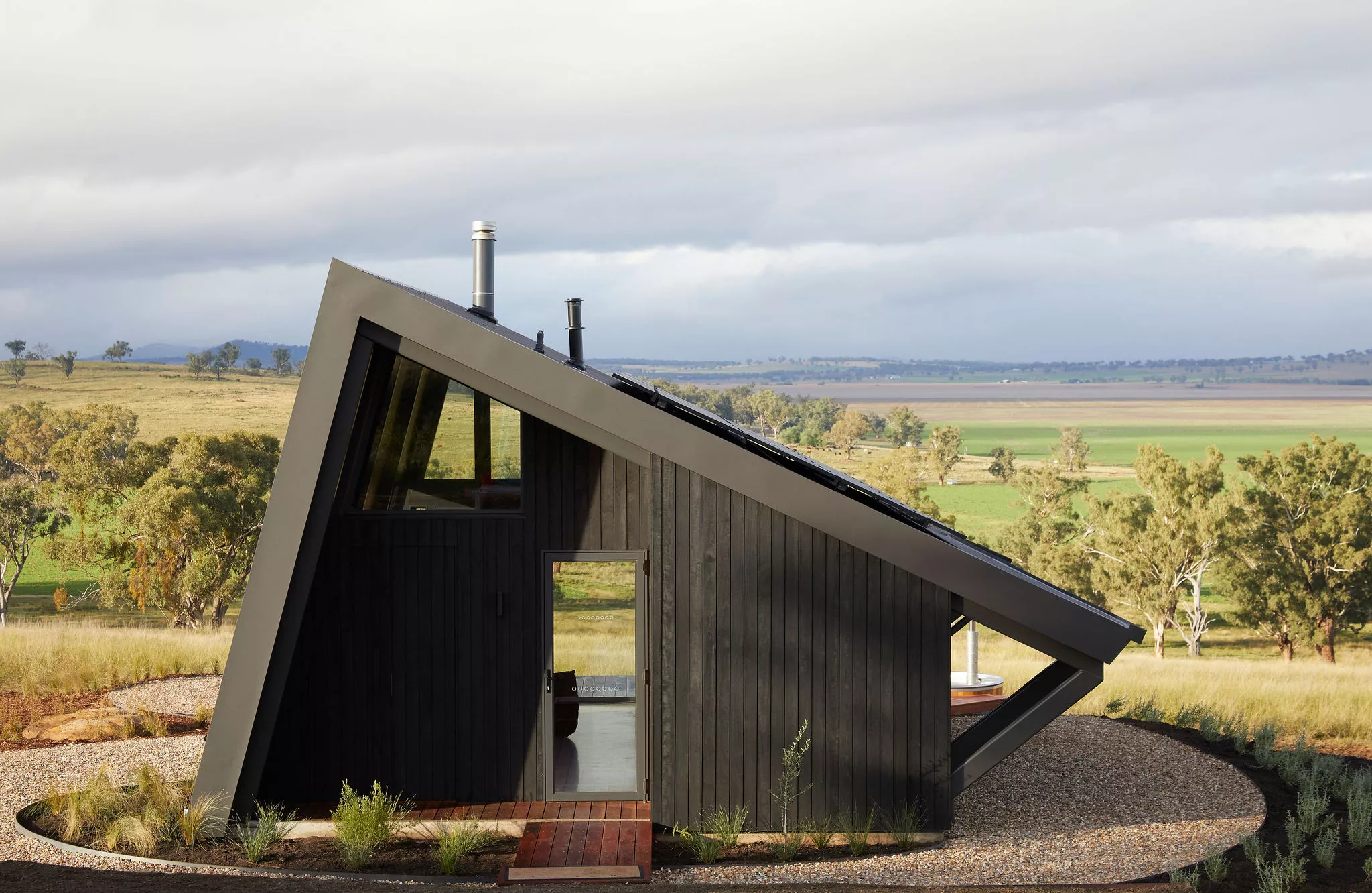 The Gilay Estate is finished in charred timber, with a sloping metal roof that protects its glazing from the harsh summer sunshine