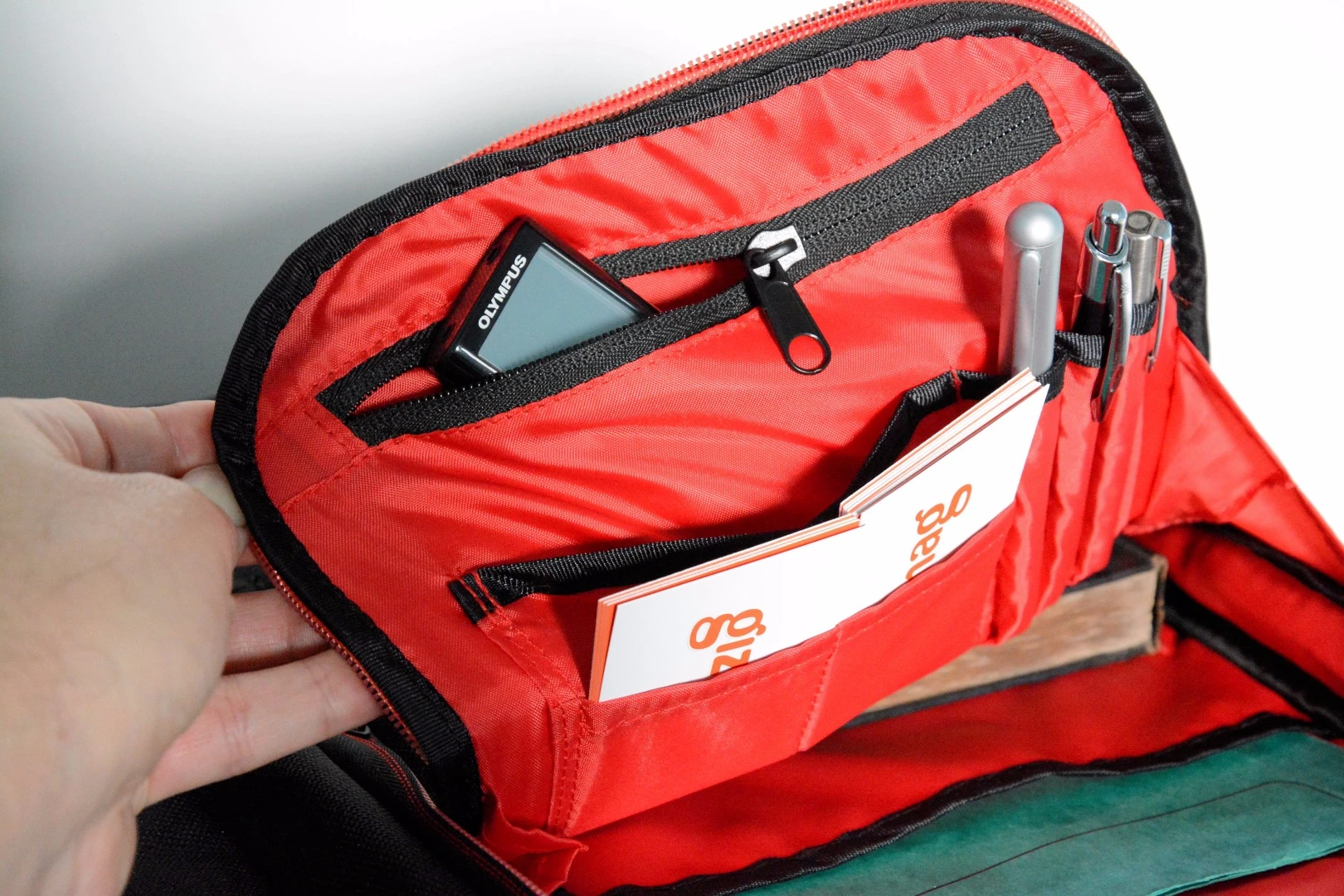 The front compartment has a non-padded sleeve for document storage, a zippered pocket, holders for business cards and pens, and a key hook
