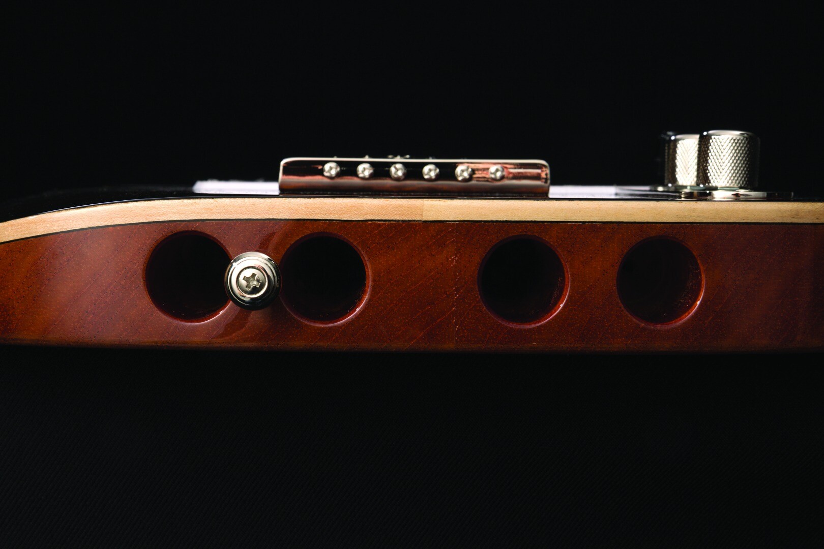 Michael Kelly Guitars has routed four holes in the back of the body to help lighten the load of its Enlightened Series guitars
