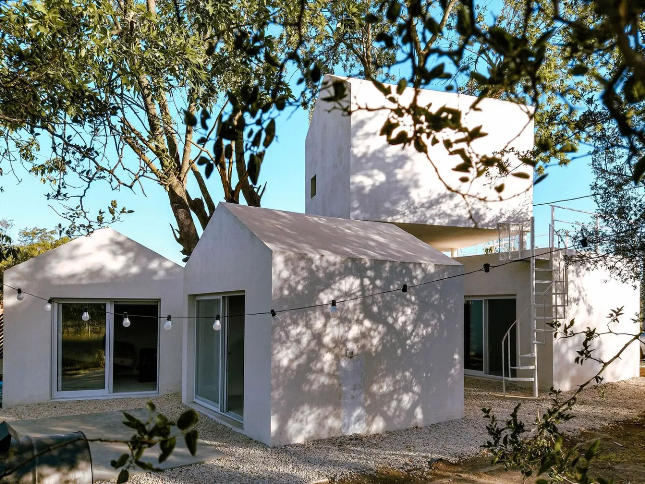 The trees are incorporated into the design in such a way that they provide a natural cooling system for the house in summer