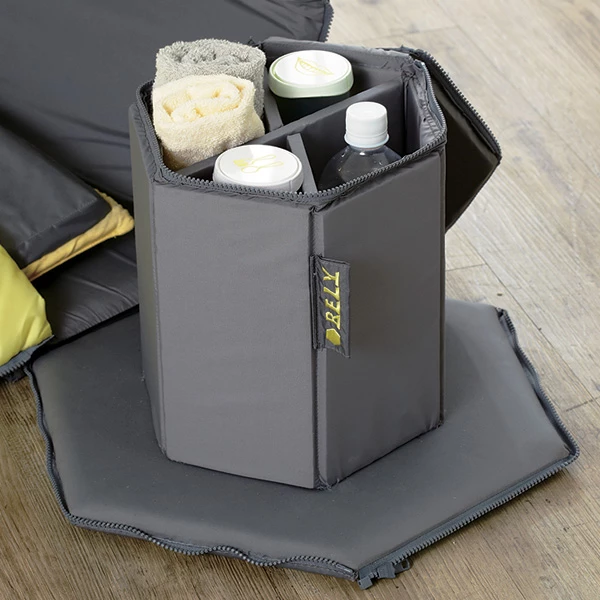 The kit contains a roll-out sleeping mat and bag, overhead light shelter, bottle of water, portable reading lamp, stool, storage compartment, tableware and toiletries