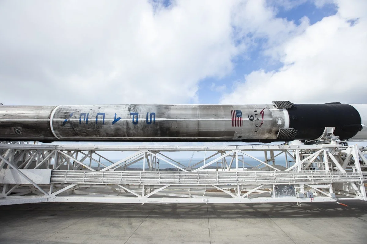 A scorched Falcon 9 is rolled out to the launchpad