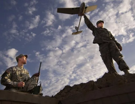 Spc. Ted Trenary and Pfc. Kevin Tirserio (right), from the 101st Airborne Division, prepare to launch the Raven unmanned aerial vehicle at Forward Operating Base McHenry, Iraq. The Raven is being used to hunt for roadside bombs.