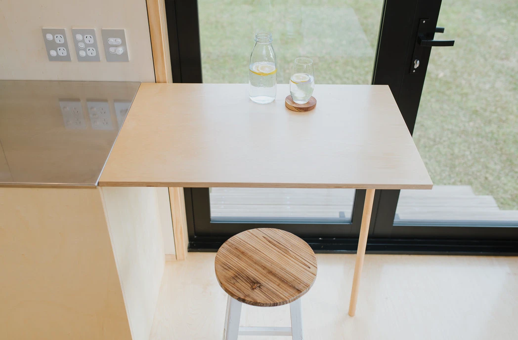 The First Light Tiny House's kitchen features a small folding table