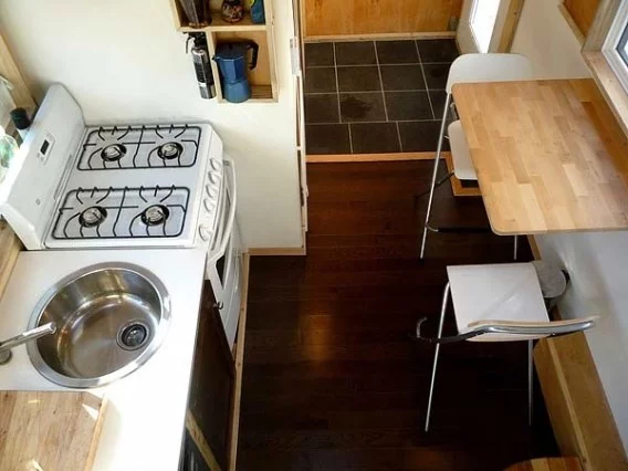 The interior features a living area with sofa bed, raised sleeping quarters and a fully functional kitchen