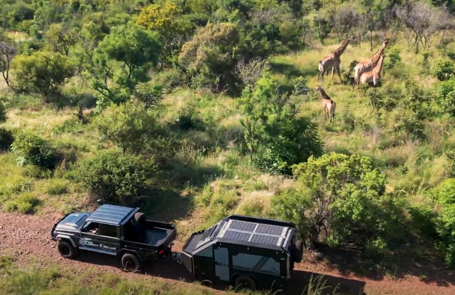 The Berg CX6 and its tow Land Cruiser take in some African scenery that includes a tower of giraffes