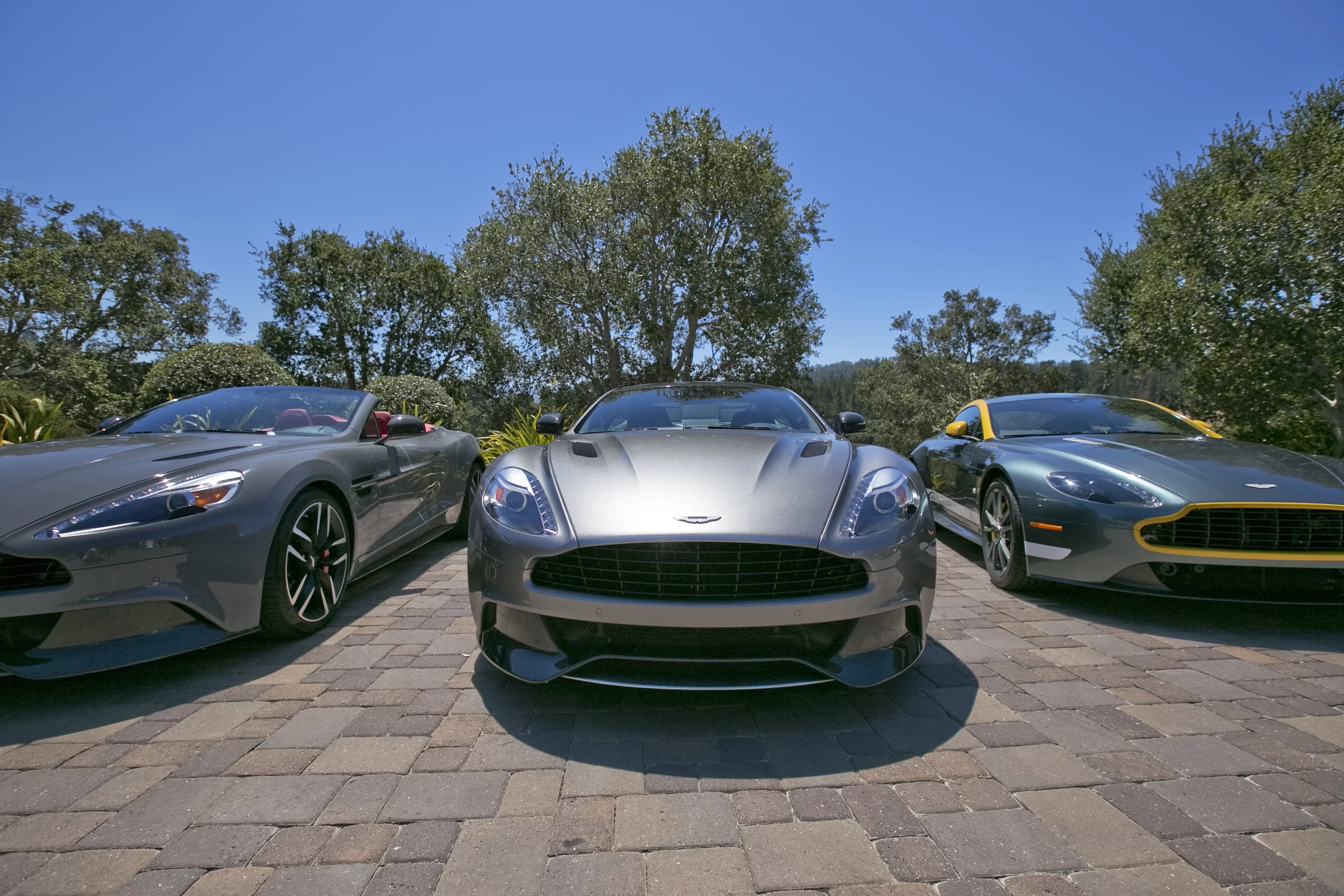 A trio of assorted Aston Martins were available for invited guests to drive at the "drive and view" event in Monterey (Photo: Angus MacKenzie/Gizmag.com)