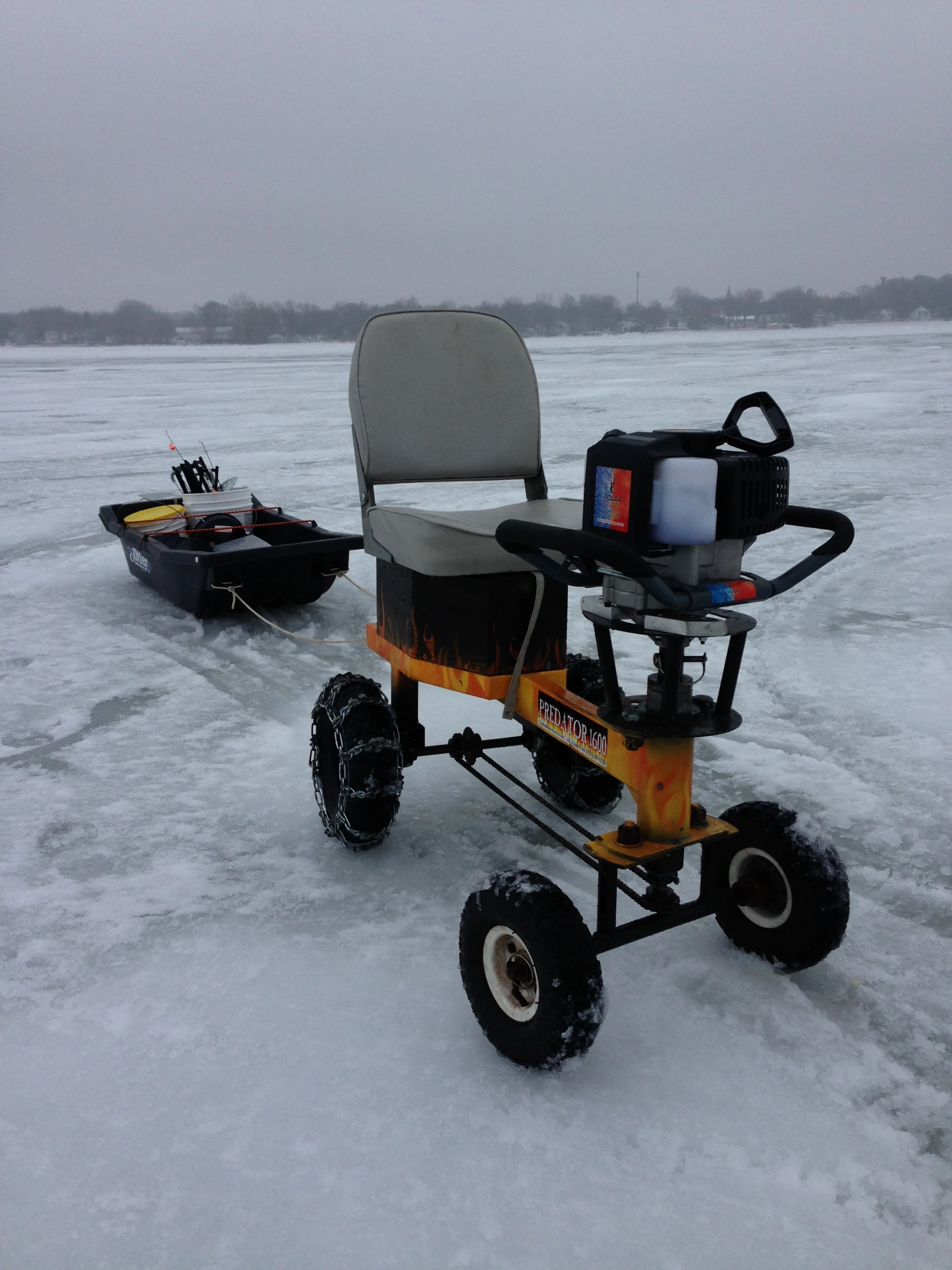 The auger, along with the rest of the user's gear, is towed behind in a sled