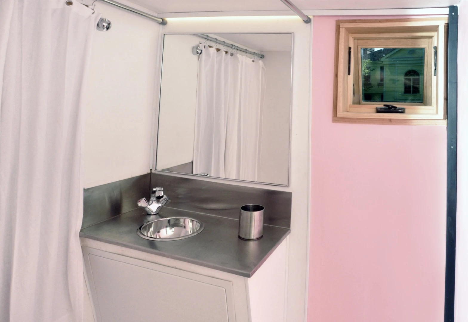 The bathroom includes a sink, shower (which drains into the floor), and a toilet