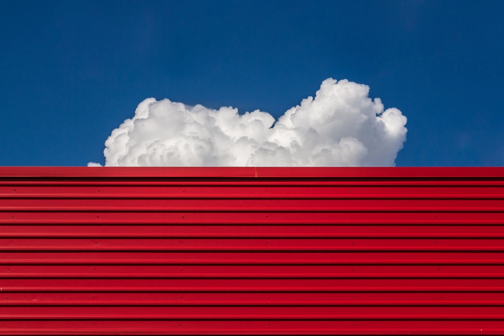 Jeremy Walter frames the white clouds against this red building nicely