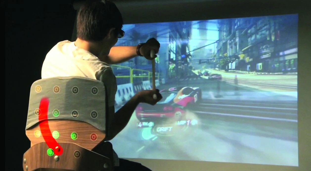 Surround Haptics enhances video game play by using an array of vibrating actuators in a chair to create the tactile illusion of continuous strokes on the player's back, illustrated in red (Image: Disney Research, Pittsburgh)