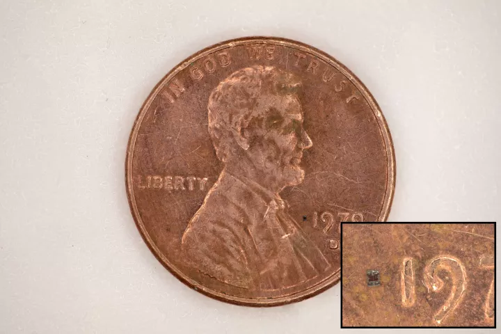 A microrobot, fully integrated with sensors and a computer, sitting on top of a US Penny, for scale