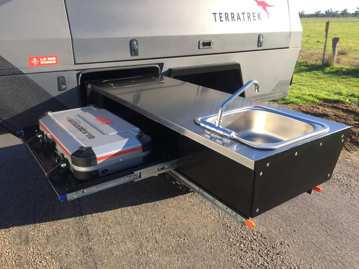 The slide-out kitchen comes with a sink and dual-burner stove