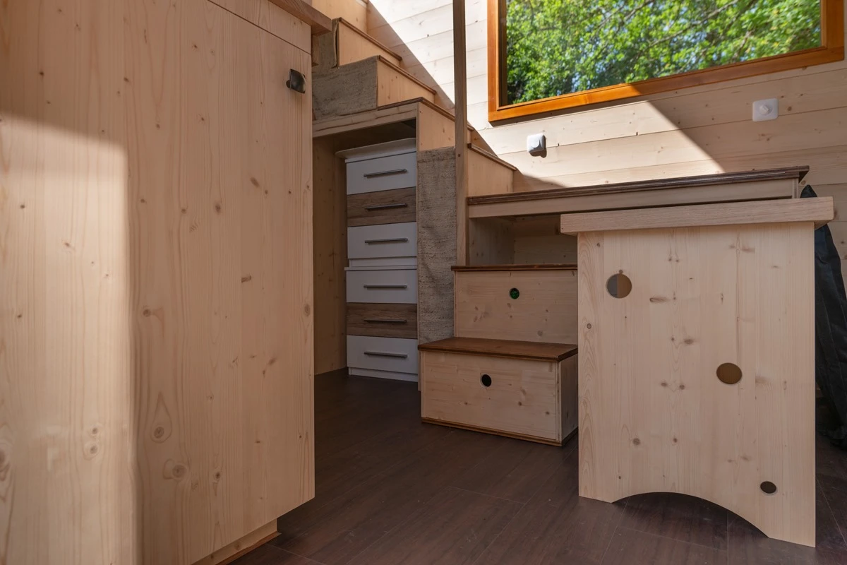 Visitors enter into a small home office area, which is really just a desk that's part of the storage-integrated staircase