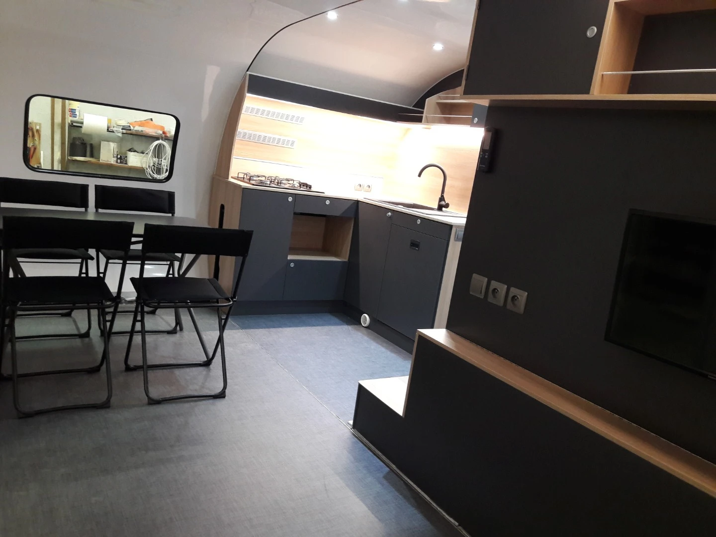 The front module contains the dining area and lounge, while the central module is dedicated to the kitchen and bathroom
