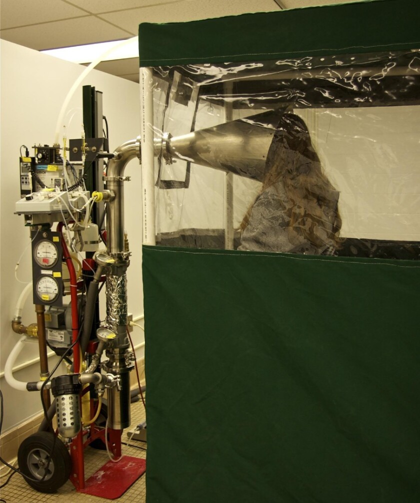A study participant sits in the Gesundheit II machine, which is used to capture and analyze influenza virus in exhaled breath