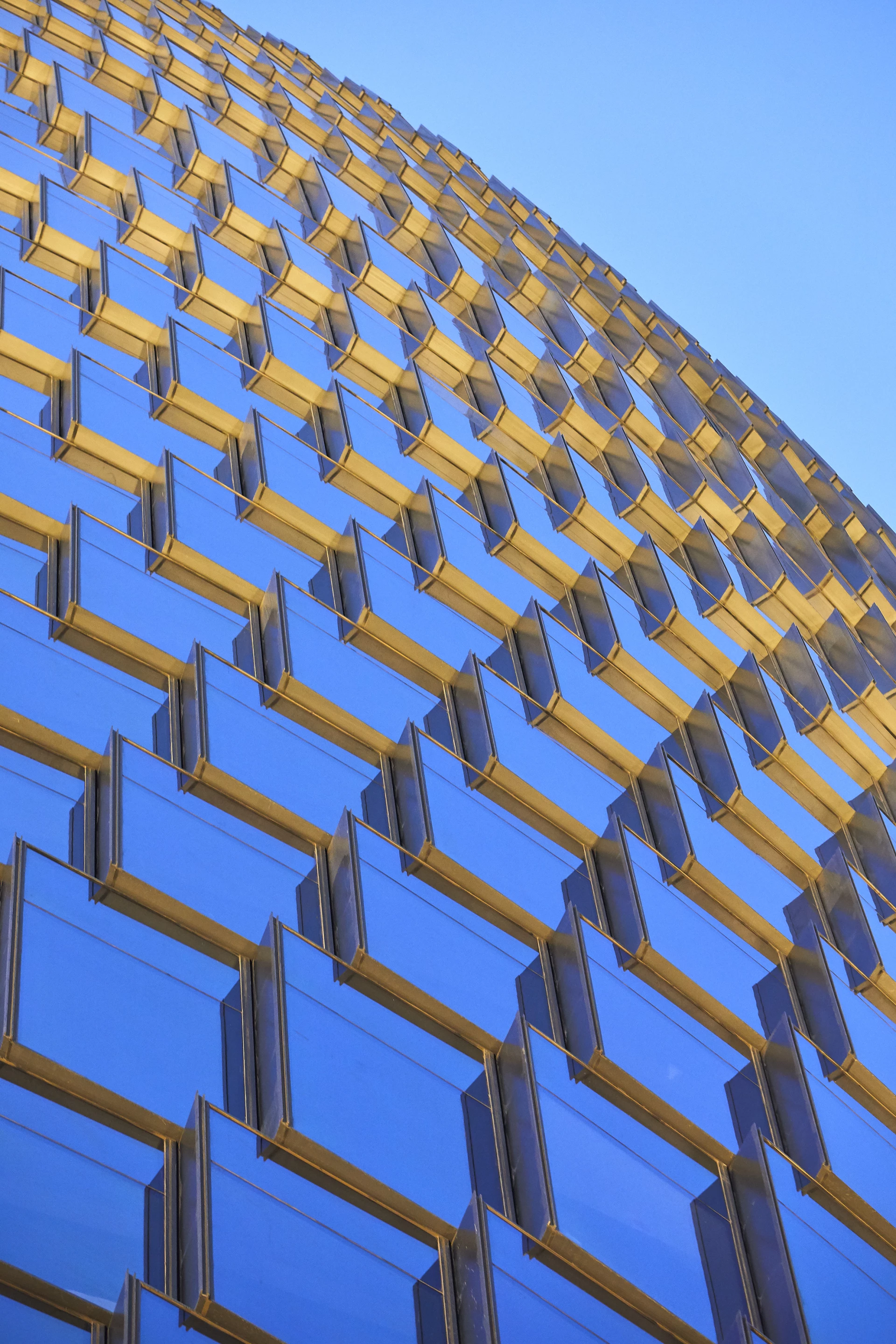 "Leeza Soho double-insulated, unitized glass curtain wall system steps the glazing units on each floor at an angle, providing narrow ventilating registers to draw outside air through operable cavities where required; creating extremely efficient environmental control for each floor," says ZHA
