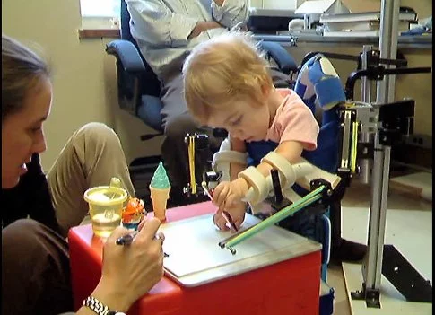 Emma in the original WREX wheelchair, before her 3D printed exoskeleton was made.