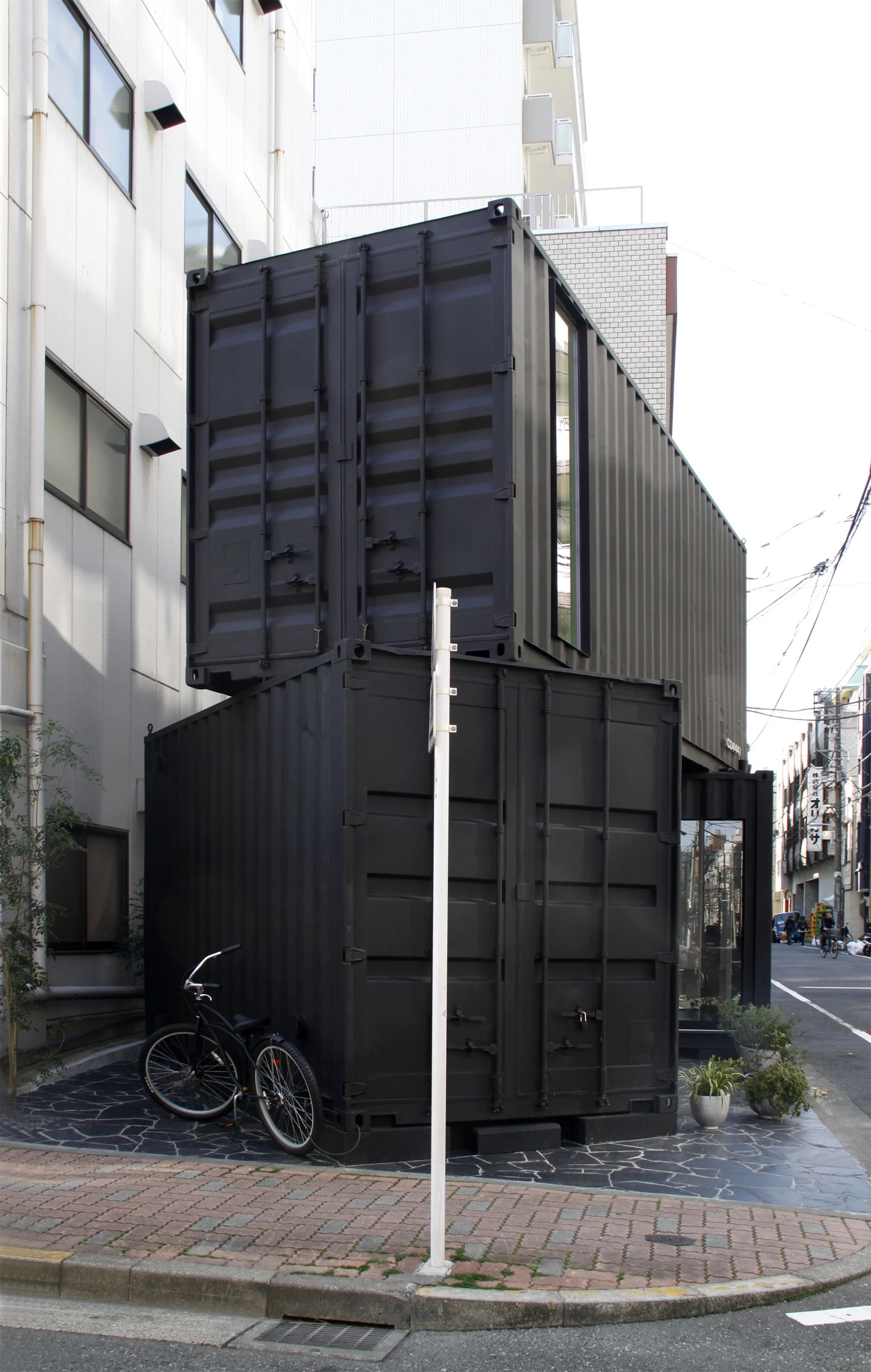 The two shipping containers appear to have been carelessly stacked on top of one another