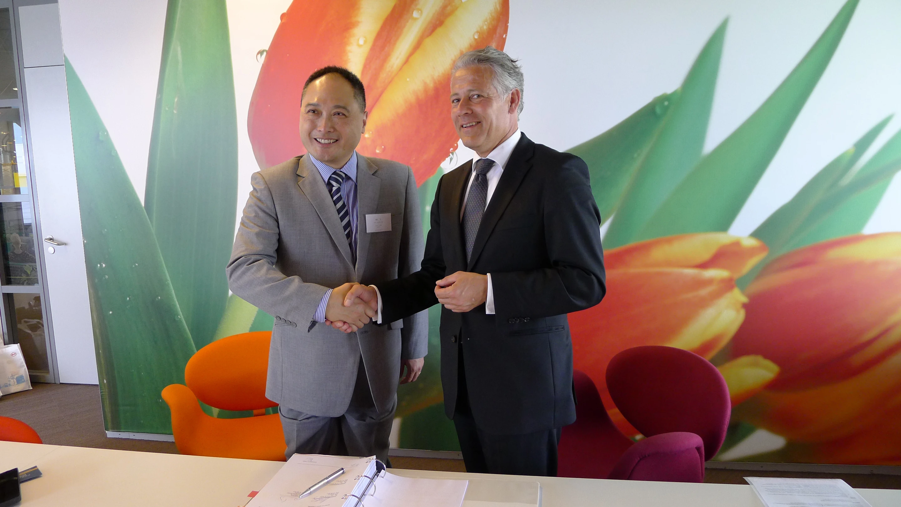 Jos Nijhuis of the Schiphol Group and Isbrand Ho from BYD Europe sign the contract