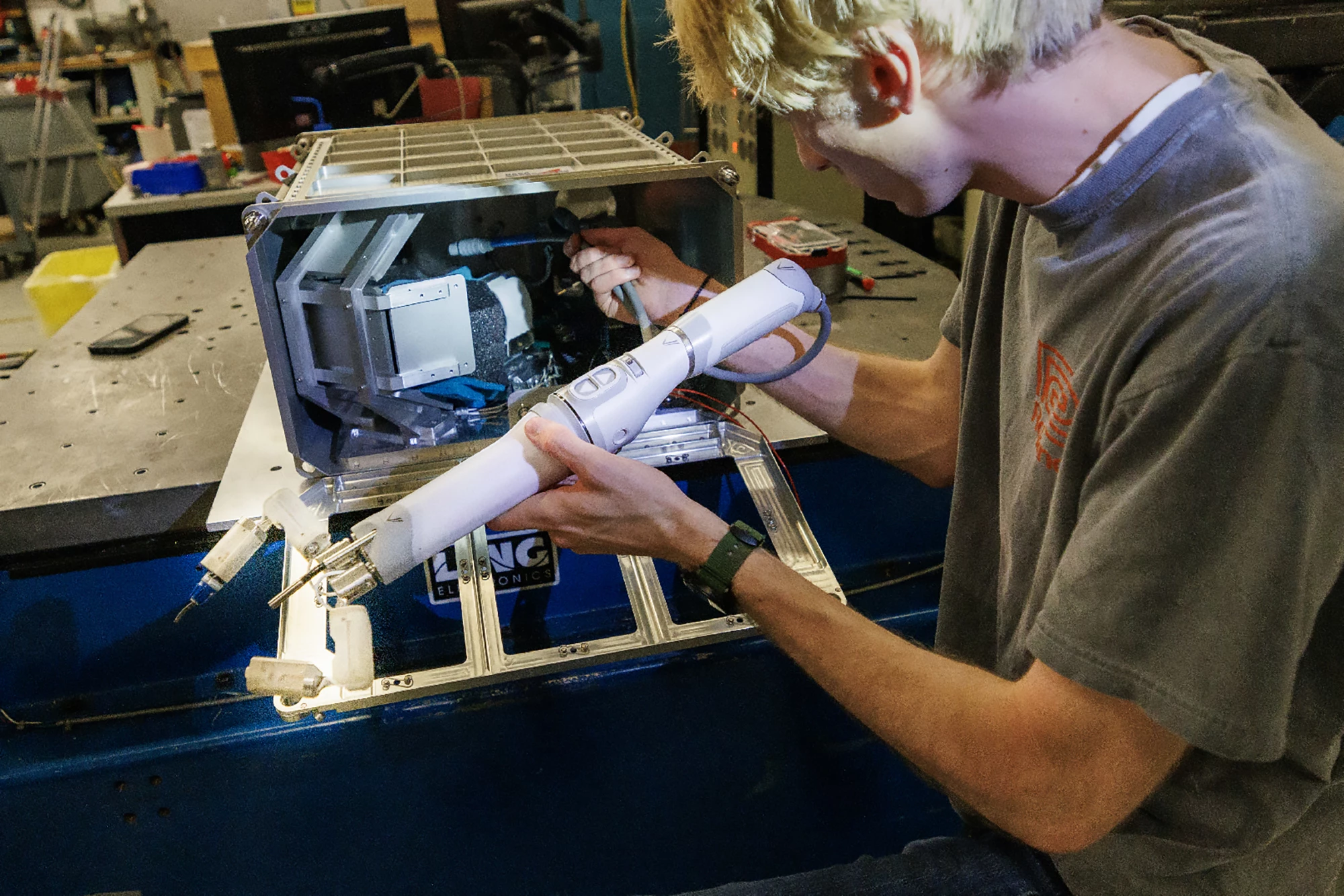 Senior mechanical engineering major Sean Crimmins loads MIRA's robotic arm into its case
